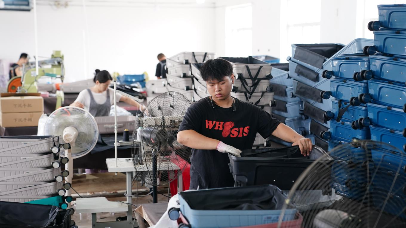 7月4日，工人在白沟新城鹏杰皮具有限公司生产车间忙生产、赶订单。孙珞瑜摄